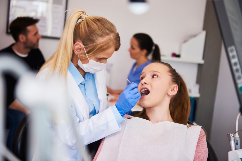 a girl is getting dental treatment